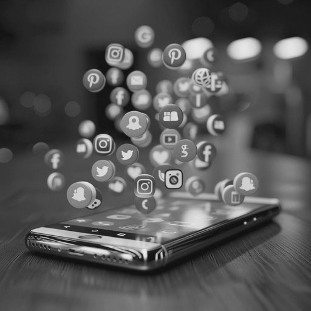 Smartphone with social media icons representing content creation, audience engagement, and social media marketing